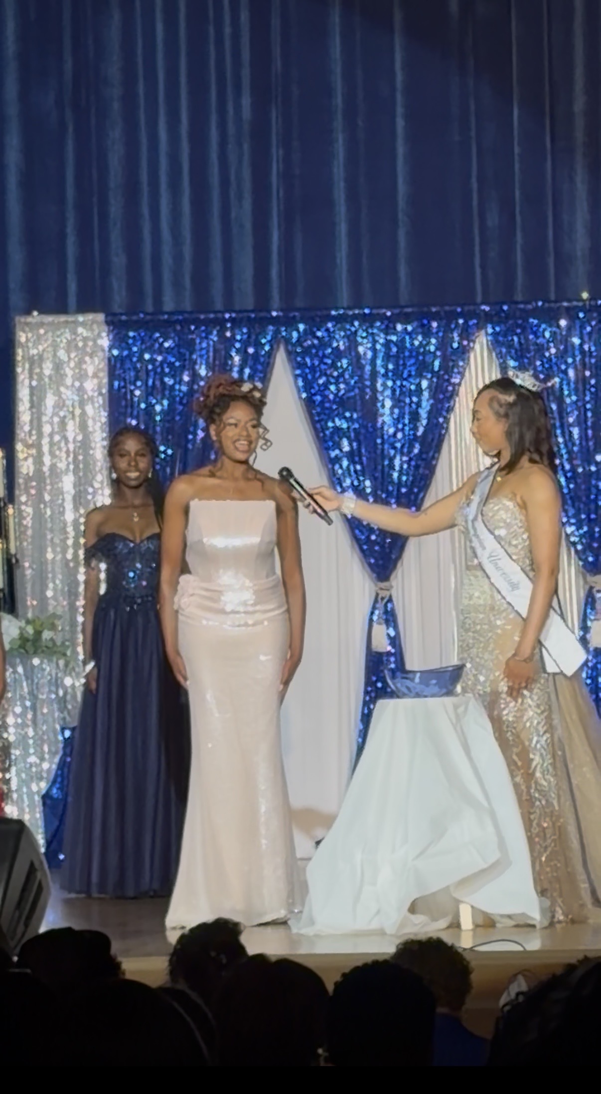 Contestant in a white evening gown during a stage interview